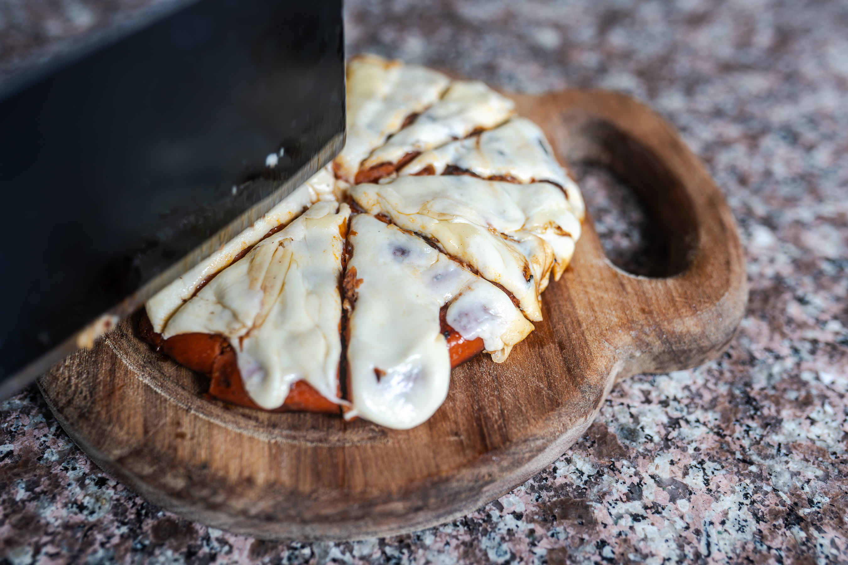 Corte con queso derretido en tabla
